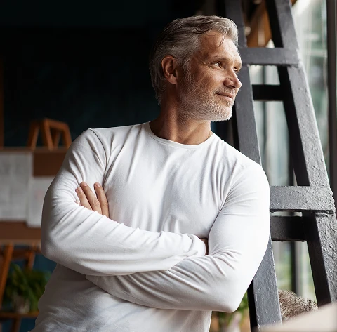 Focused man in a white shirt looking toward bright light, symbolizing renewed mental energy and brain health
